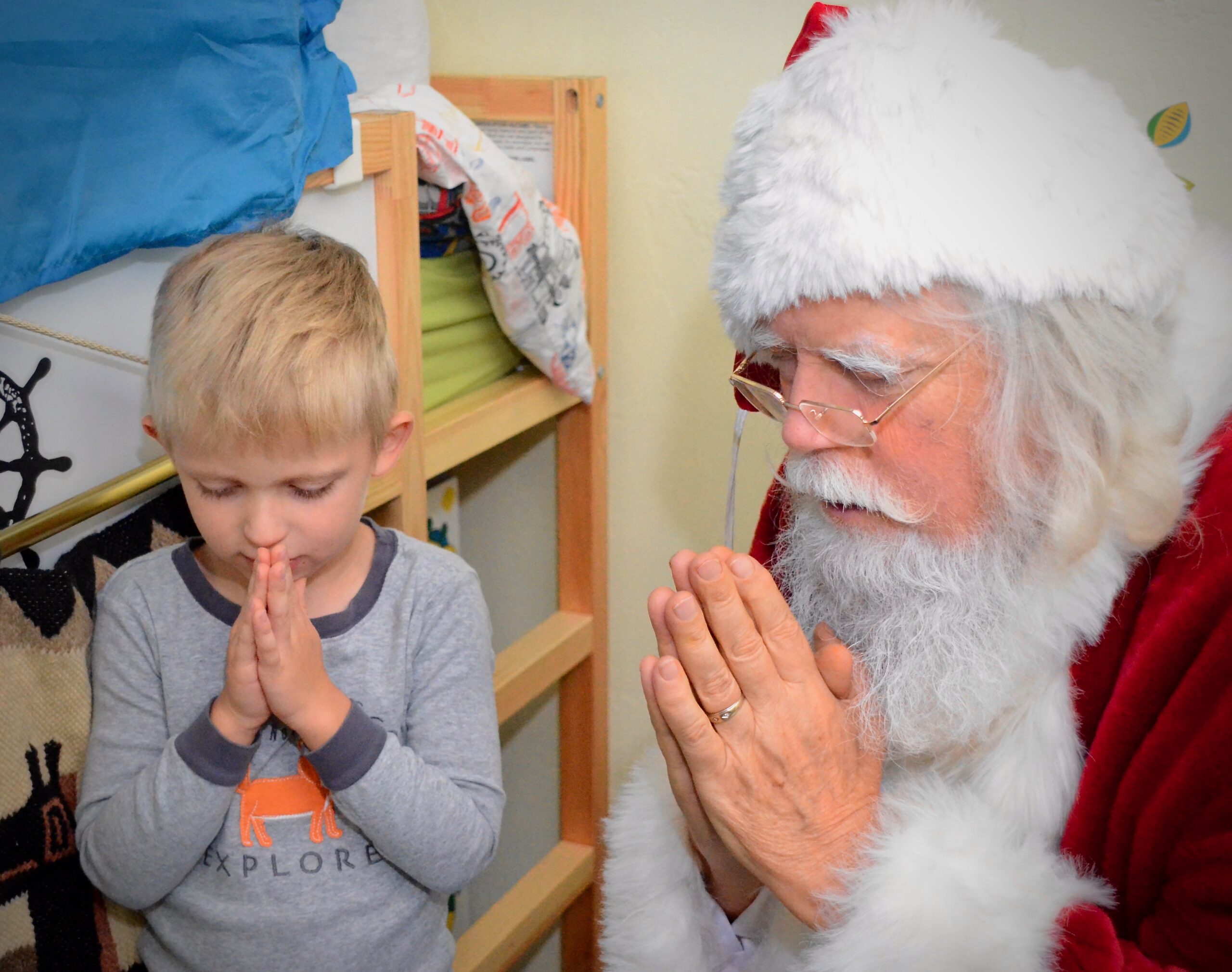 Praying with Santa Santa praying with young child